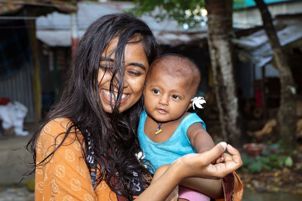 শিশুকে কোলে নিয়ে একজন বাংলাদেশি মা; প্রতিনিধিত্বমূলক স্টক ছবি, আসক ফাউন্ডেশনের সমাবেশ নয়